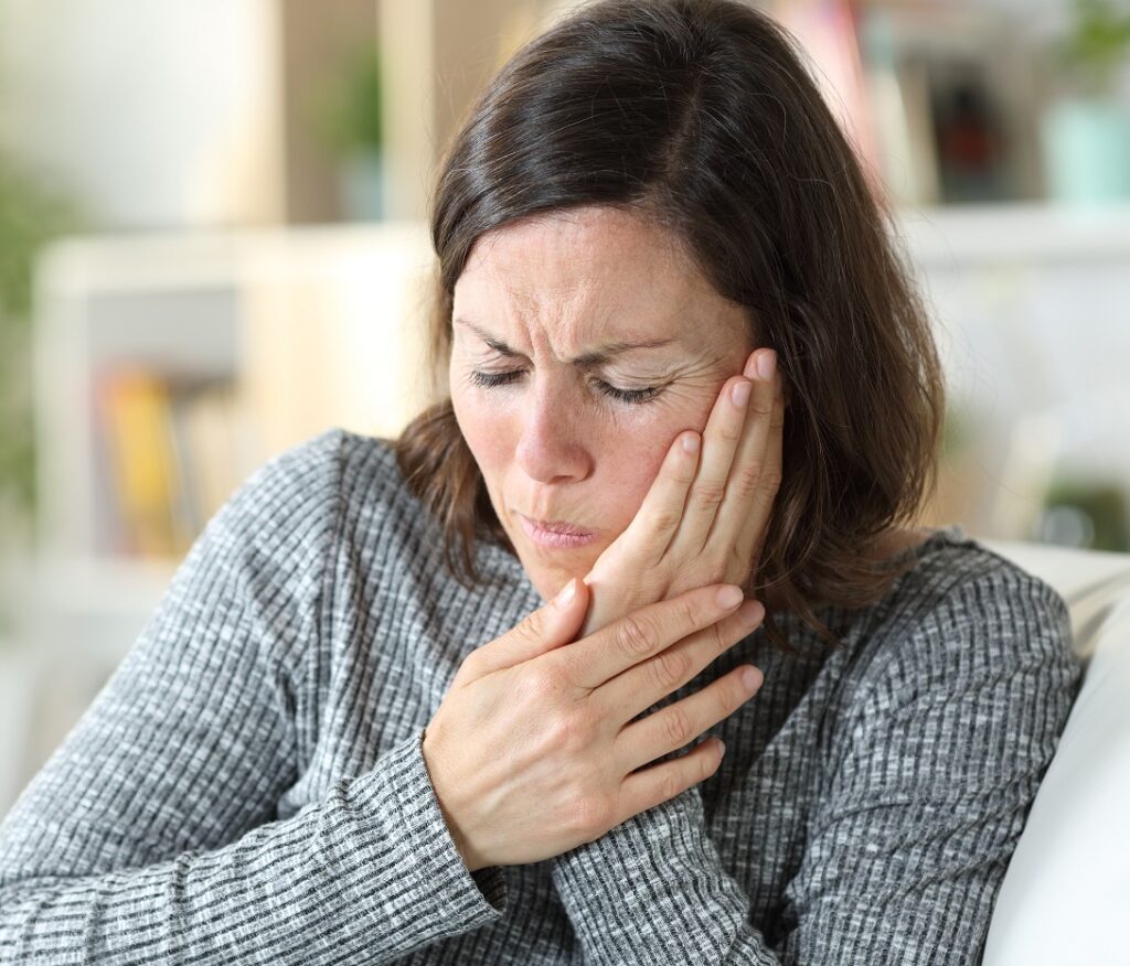 Middle age woman suffering toothache and tmj at home