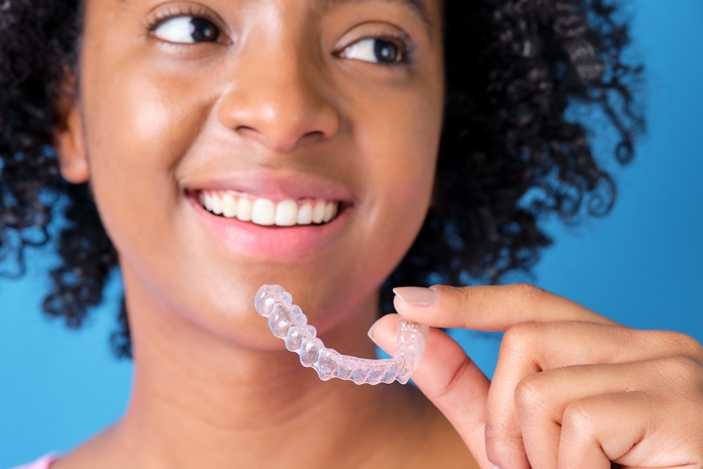 Close up of woman smiling while holding a tray of clear aligners near Waxhaw